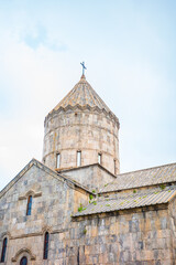 Close-up of an ancient Armenian monastery featuring its iconic dome topped with a cross, stone walls, and timeless medieval architecture of Tatev, Armenia famous tourist attraction