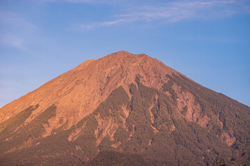 Detailed view of Mount Semeru’s towering volcanic peak rising sharply under a bright blue sky, showcasing the rugged textures of Indonesia’s highest active volcano.
