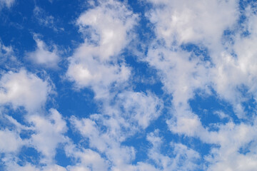 Blue sky with scattered clouds. Bright natural background of scattered clouds in clear blue sky.