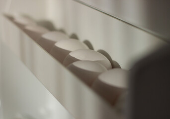 Homemade chicken eggs on the shelf of the refrigerator on a white background. Chicken eggs in the...