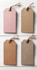 Four blank paper tags, two pink, two kraft, with twine, on white wood