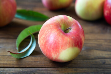 Ripe delicious red with yellow apple on wooden table. Fruit dessert. Selective focus.