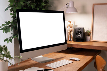 A professional workspace with a modern desktop computer featuring a blank white screen, surrounded by stylish office decor and plants. Contemporary work environment.