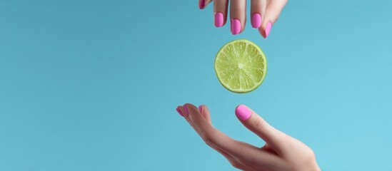 Lime slice floats between manicured hands against a clean, bright blue backdrop