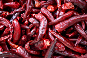 A pile of dried red peppers. Their intense red color and delicate texture stand out.
