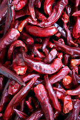 A pile of dried red peppers. Their intense red color and delicate texture stand out.
