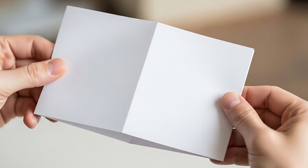 Obraz premium Hands holding a blank bi-fold brochure, mockup for invitation or flyer