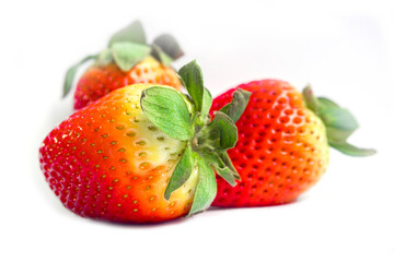 Bright red strawberry placed on a white background.
