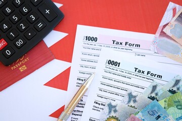 Bahraini dinar money bills and calculator with tax form on flag. Taxation and accounting concept