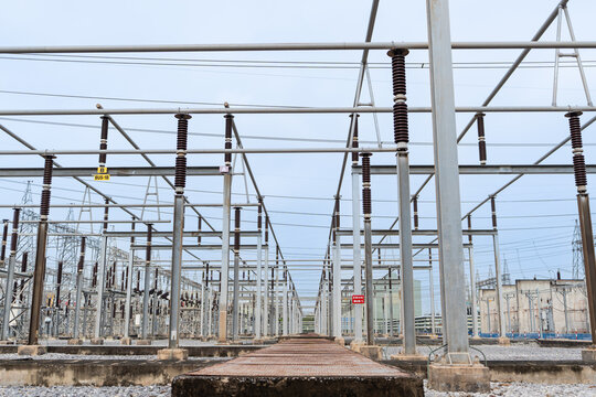 Modern electrical substation with metal frameworks, ceramic insulators, and high-voltage lines. Industrial energy infrastructure for electric transmission and power grid systems. - Powered by Adobe