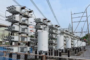 Side view of outdoor capacitor bank system with reactors used in high voltage substations for reactive power compensation and power factor improvement in industrial energy infrastructure. © JD Studio