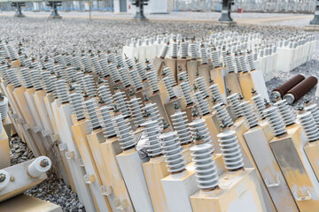 Damaged capacitor units with ceramic insulators removed from high voltage electrical substation,...