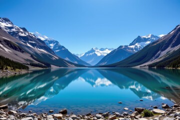 Obraz premium crystal clear mountain lake surrounded by snowy peaks, deep blue sky reflecting on the water surface, untouched pristine environment, creating a peaceful and majestic alpine scene.
