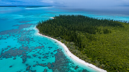 An aerial view of a secluded white sand beach on Ilot Brosse, New Caledonia. The pristine beach is...