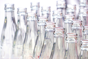 Many empty glass bottles are stacked together.