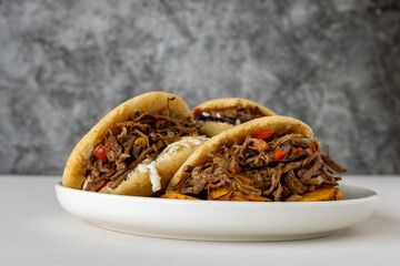 Delicious Venezuelan arepa stuffed with shredded beef and cheese, a traditional Latin American street food dish