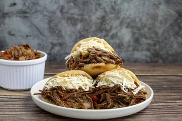 Delicious Venezuelan arepa stuffed with shredded beef and cheese, a traditional Latin American street food dish