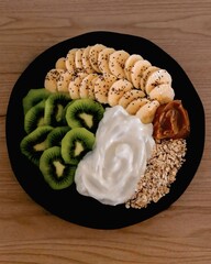 The image shows a healthy breakfast bowl, often referred to as a yogurt bowl or a smoothie bowl, containing several ingredients arranged on a plate. 