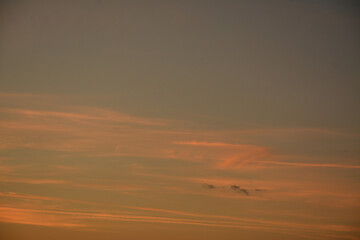 Evening sky with orange rays of sun among the clouds