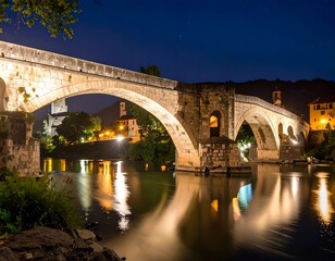 Obraz premium Ancient stone bridge at night, reflecting in calm river