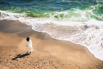 A woman enjoying the ocean. From above