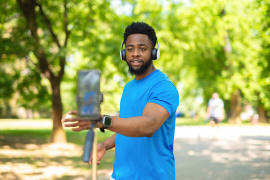 African american fitness vlogger recording video with smartphone outdoors.
- Powered by Adobe