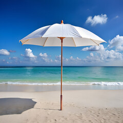 Single white beach umbrella on a sandy beach with turquoise ocean and blue sky with clouds