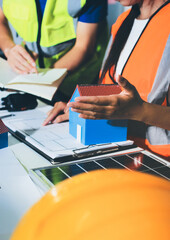 Closeup of team of industrial engineers meeting analyze machinery blueprints consult project on table in manufacturing factory. Working in manufacturing plant or production plant.