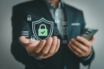 Businessman hand holding digital shield with lock icon, symbolizing cybersecurity, data protection, privacy, and secure online access, with password and lock graphics, modern technology concept