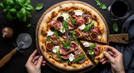 Overhead view of a person taking a slice of a gourmet prosciutto and fig pizza, elegantly served with fresh arugula and a glass of red wine