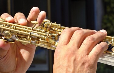 Musician's hands playing soprano saxophone