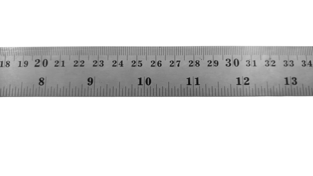 A long stainless steel ruler with dual scales: centimeters and inches. It features a hanging hole at the right end and clear numbers for precise measurements.