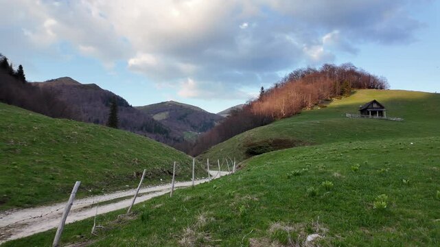 A lonely house on a green hill in a mountains landscape near a lake, no people.
