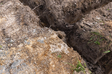 An elevated view of freshly dug earth trenches, showcasing the soil texture