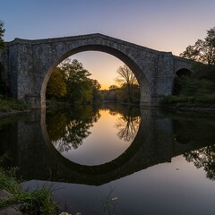 Majestic Stone Arch Bridge Sunset Reflection in Calm River, Serene Landscape.