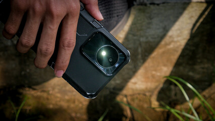 Hand Holding Smartphone with Flashlight On