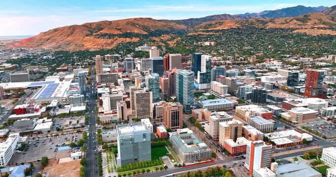 Gorgeous mountains surround the urban area of Salt Lake City, Utah, USA. Modern city panorama from drone at daytime.