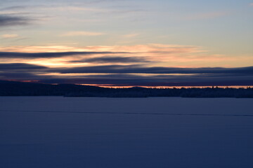 Fototapeta premium On a frosty winter evening we meet the sunset on the lake.