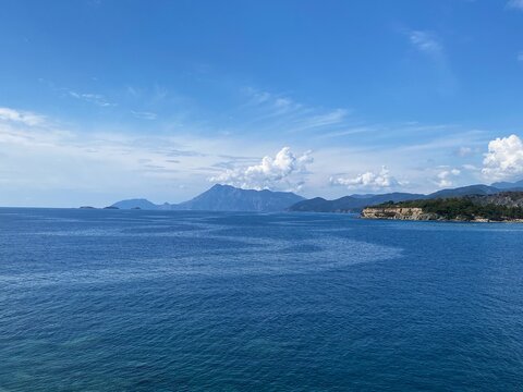 Panoramic view of the mountains and rocks of the Phaselis coast with the blue and clear water of the Mediterranean Sea near Kemer in sunny weather. Antalya, Turkey.
