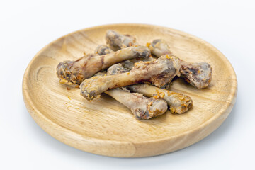 Chicken bone wooden plate leftover food waste white background cooked meal snack unhealthy greasy closeup