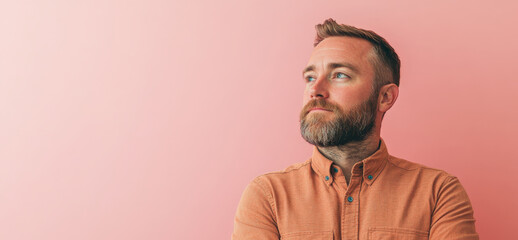 Fototapeta premium Confident Man in Casual Attire Posing Against a Pink Background
