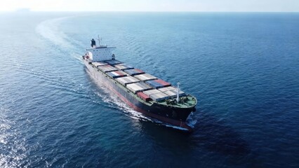 Fototapeta premium A large cargo ship cuts through the tranquil ocean waters, showcasing a powerful image of maritime transport.