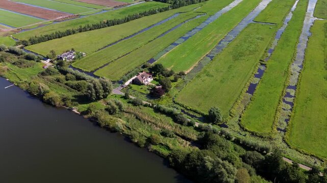 Aerial view of a rural landscape with a central road, water body, irrigated fields, and scattered houses. The scene highlights agricultural planning and natural integration.