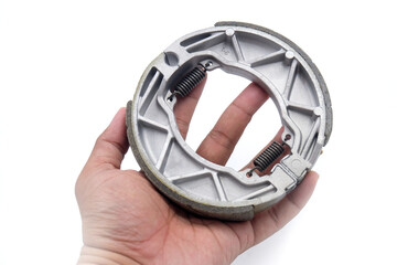 hand holding rear brake pads for the motorcycle brakes isolated on white background