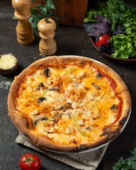 Delicious pizza with mushrooms and chicken served on dark wooden table with fresh herbs and vegetables