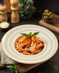 Delicious pasta dish with marinara sauce, fresh basil, and grated cheese served in a cozy dining setting