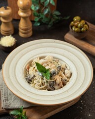 Delicious plate of pasta topped with fresh herbs and served with olives in a rustic kitchen setting