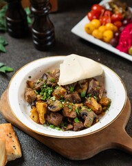 Delicious meat dish served with a side of bread and fresh vegetables in a warm rustic setting