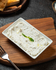 Delicious creamy dip served on a wooden board alongside toasted bread in a cozy dining setting