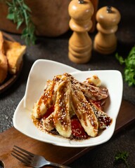 Freshly prepared sweet banana dessert with caramel sauce and sesame served on a decorative plate
